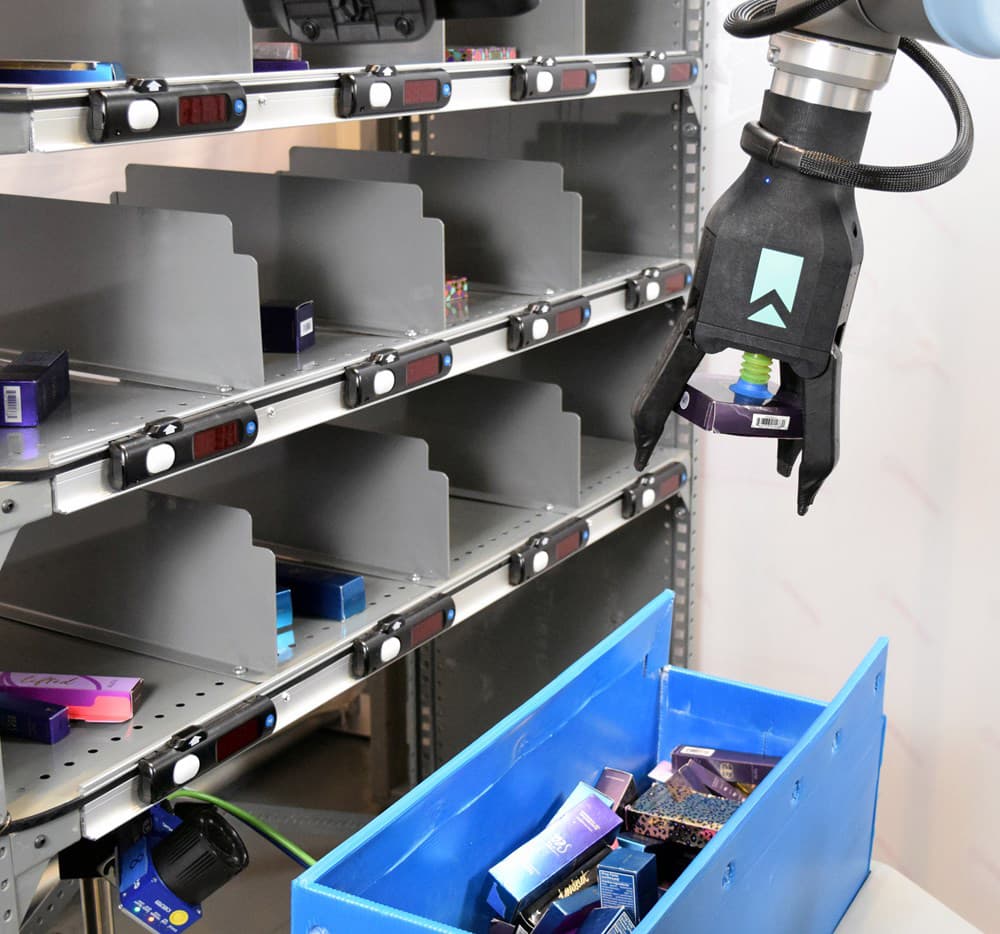 A robotic arm picking items into a tote at a fulfillment site